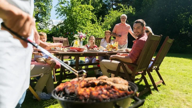 Family gathered around a backyard grill